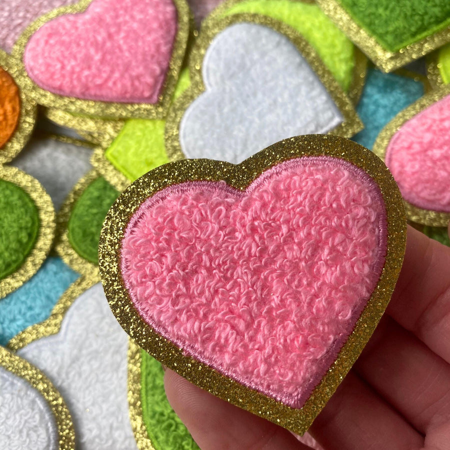a hand holding a small heart shaped cookie