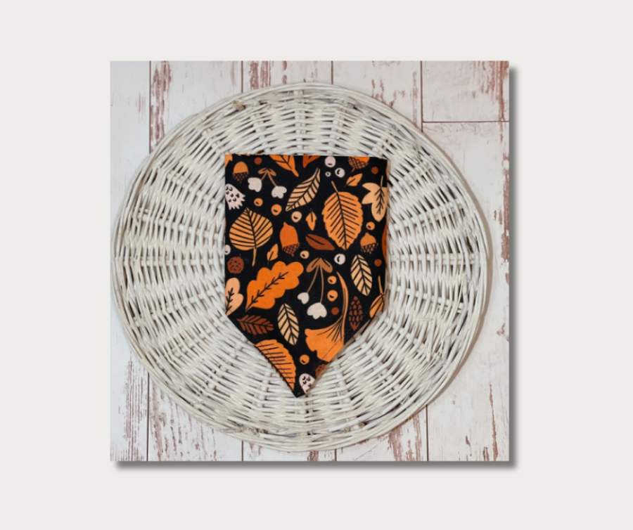dog bandana with leaves, showing side 2 print design in black, orange, cream colors