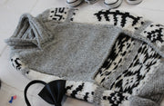 close up of underside of dog sweater, main color is gray